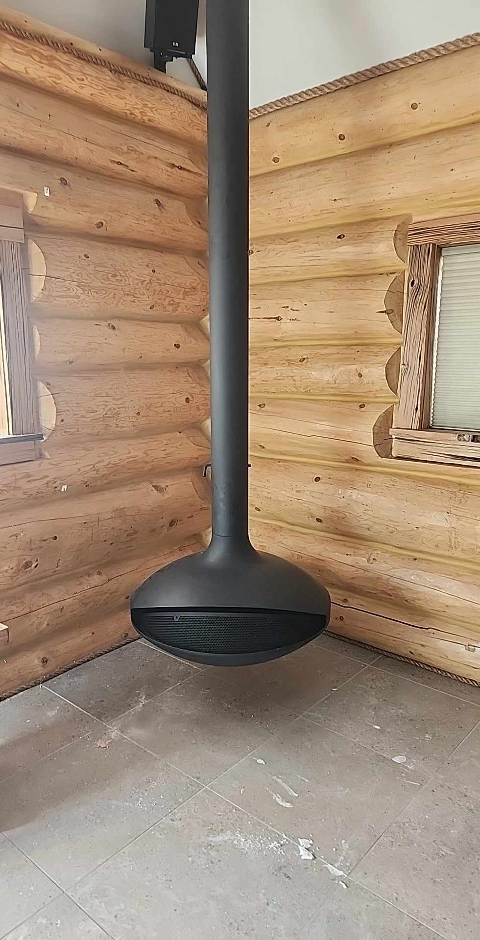 Interior renovation with hanging fireplace in log cabin